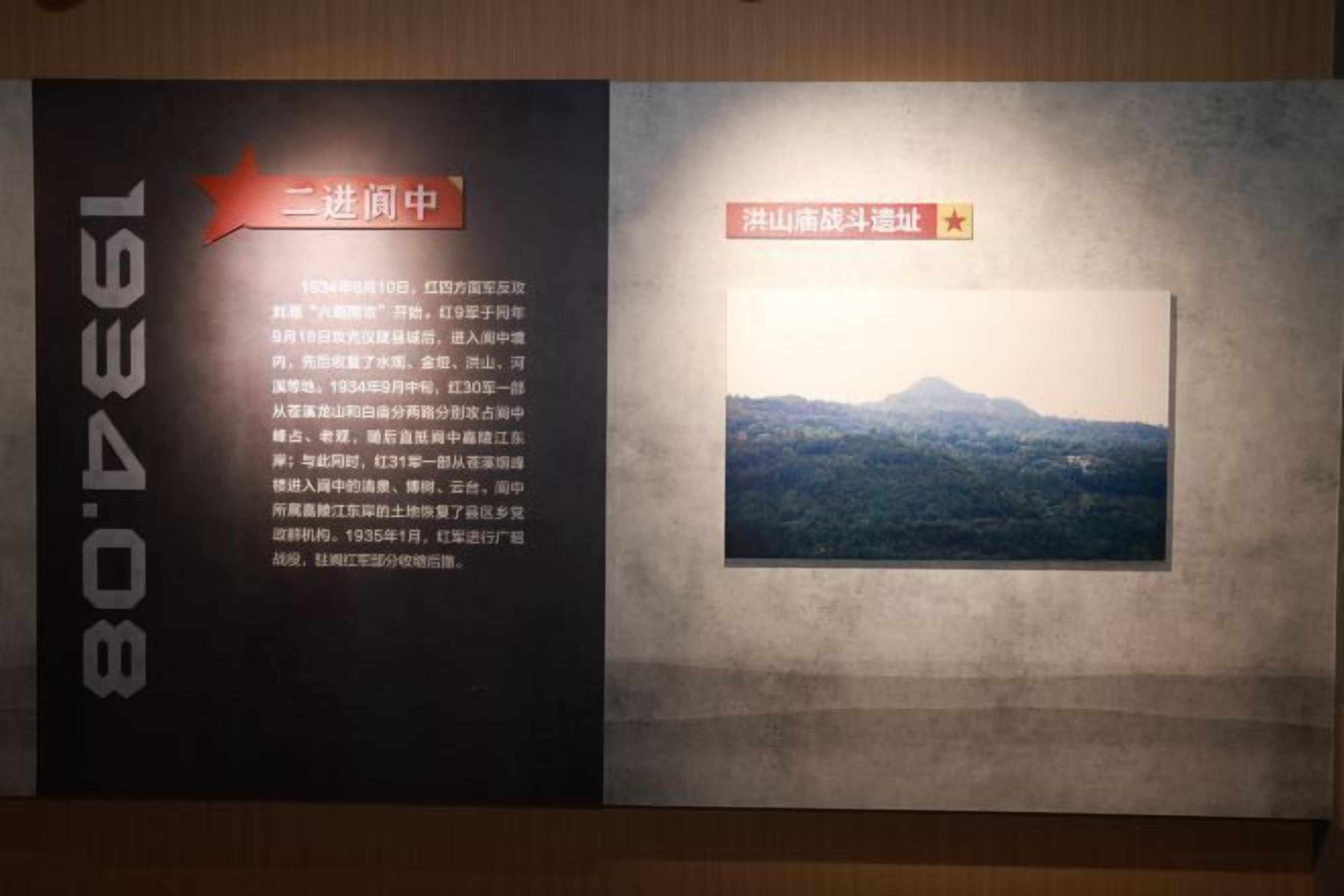 Een muur met twee informatieborden. Een bord heeft tekst en een rode ster grafiek, het andere toont een landschapsfoto met een berg en een rode ster grafiek.