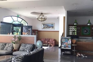 A lobby with a reception desk, seating area, and a large window. - Cloud Top Landscape Hotel (Hualien)
