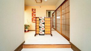 A traditional Japanese interior with tatami flooring, a shoji screen, and a decorative hanging scroll. - Yokkaichi Nishishinchi Hotel (Yokkaichi)