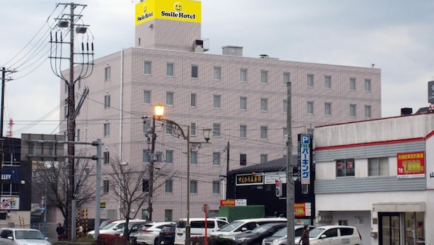 A multi-story building with a prominent yellow sign on the roof. - Smile Hotel Kushiro (Kushiro City)