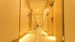 A long, well-lit hallway with a marble floor, leading to a door at the end. - Super 8 Loft(Beijing Tiananmen Qianmen Metro Station Branch) (Beijing)