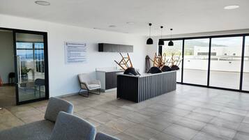 A modern reception area with a glass door, a reception desk, and a seating area with chairs.
