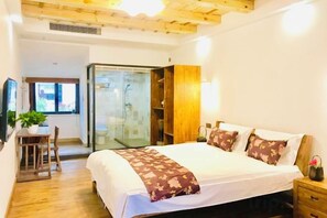 Ein Schlafzimmer mit Bett, Nachttisch und Schreibtisch mit Stuhl.