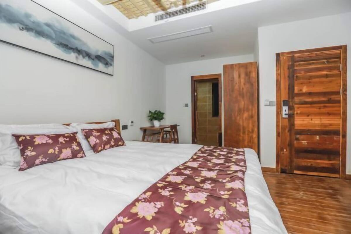 Une chambre à coucher avec un lit, un bureau et une porte en bois.