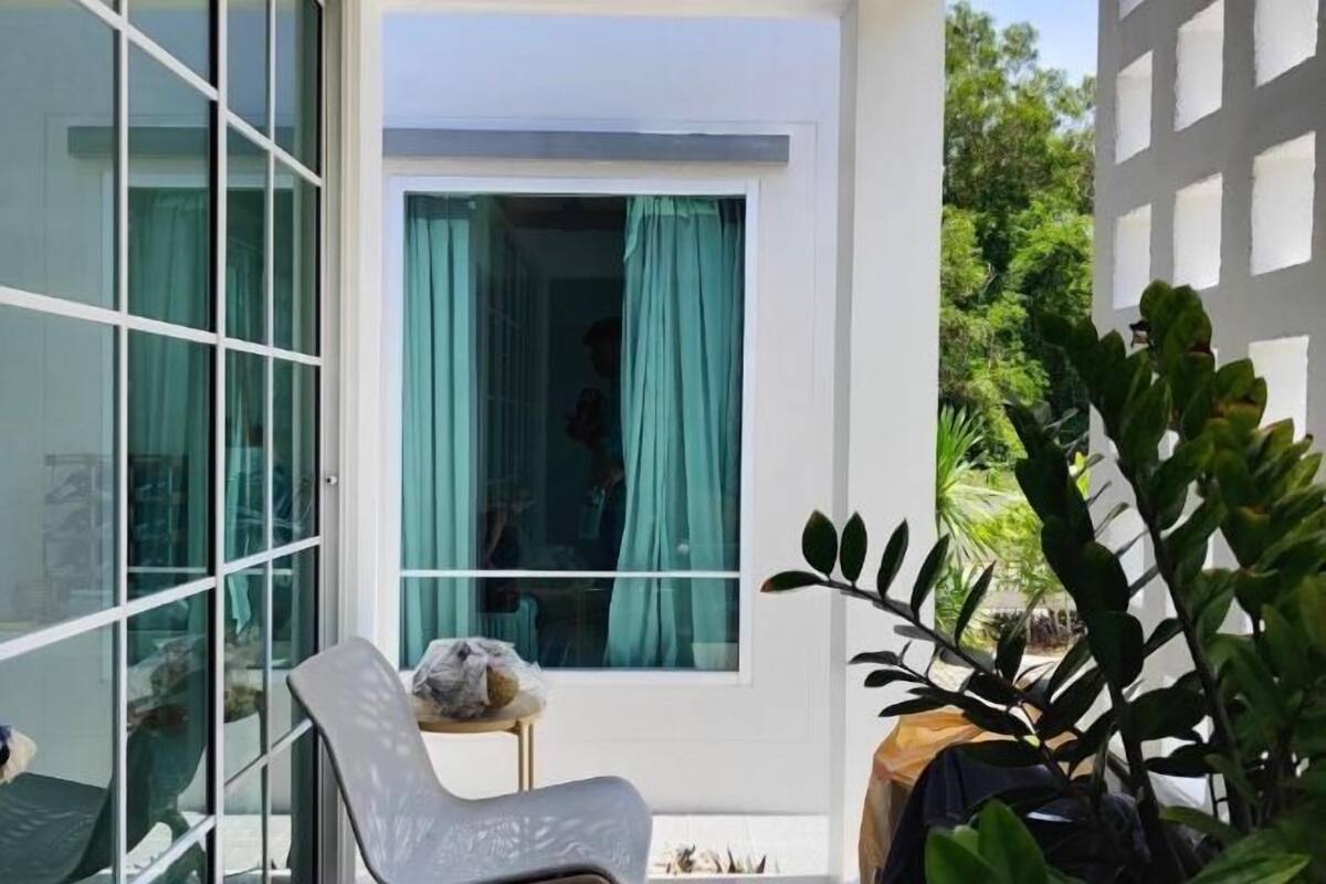 A room with a sliding glass door, a chair, and a potted plant.