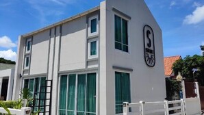 A modern building with a white facade, large windows with green curtains, and a prominent logo on the side. - Sealoft,Pattaya (Pattaya)