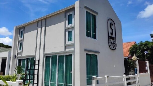 A modern building with a white facade, large windows with green curtains, and a prominent logo on the side. - Sealoft,Pattaya (Pattaya)