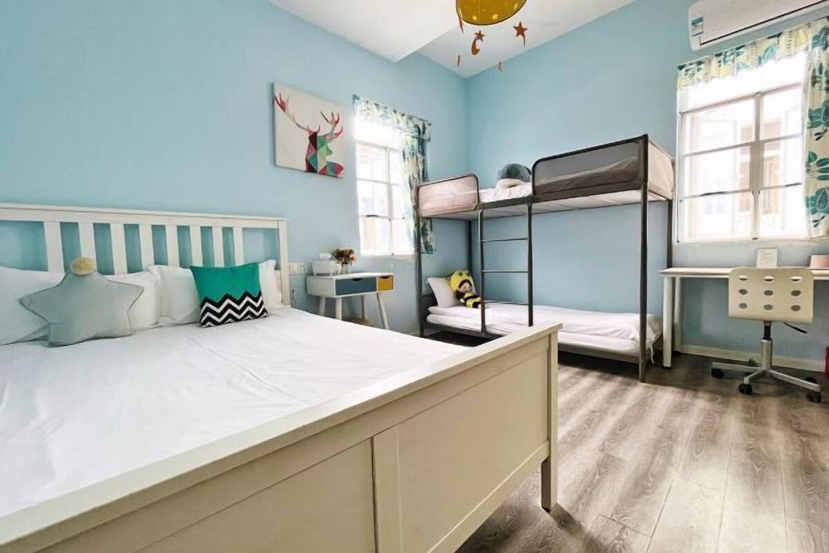 A bedroom with a bunk bed, a desk, and a chair.
