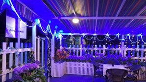 An outdoor patio area with white picket fences, tables, and chairs, decorated with string lights and floral arrangements. - Favorite Bonjour Shenzhen Seaview Meisu (Shenzhen)