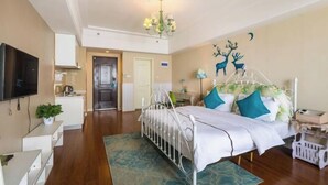 Ein Schlafzimmer mit einem Bett, einem Fernseher, einem Schreibtisch und einer Wand mit einem Hirschgemälde.