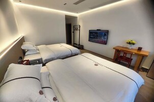 Una habitación de hotel con dos camas, un escritorio y una silla.