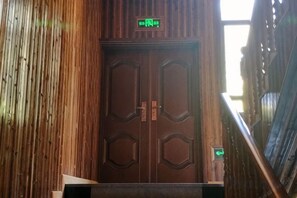A wooden door with a green exit sign above it. - Evercloud Ecological Farm (She County)