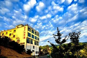 Un edificio de varios pisos con una entrada destacada y señalización.