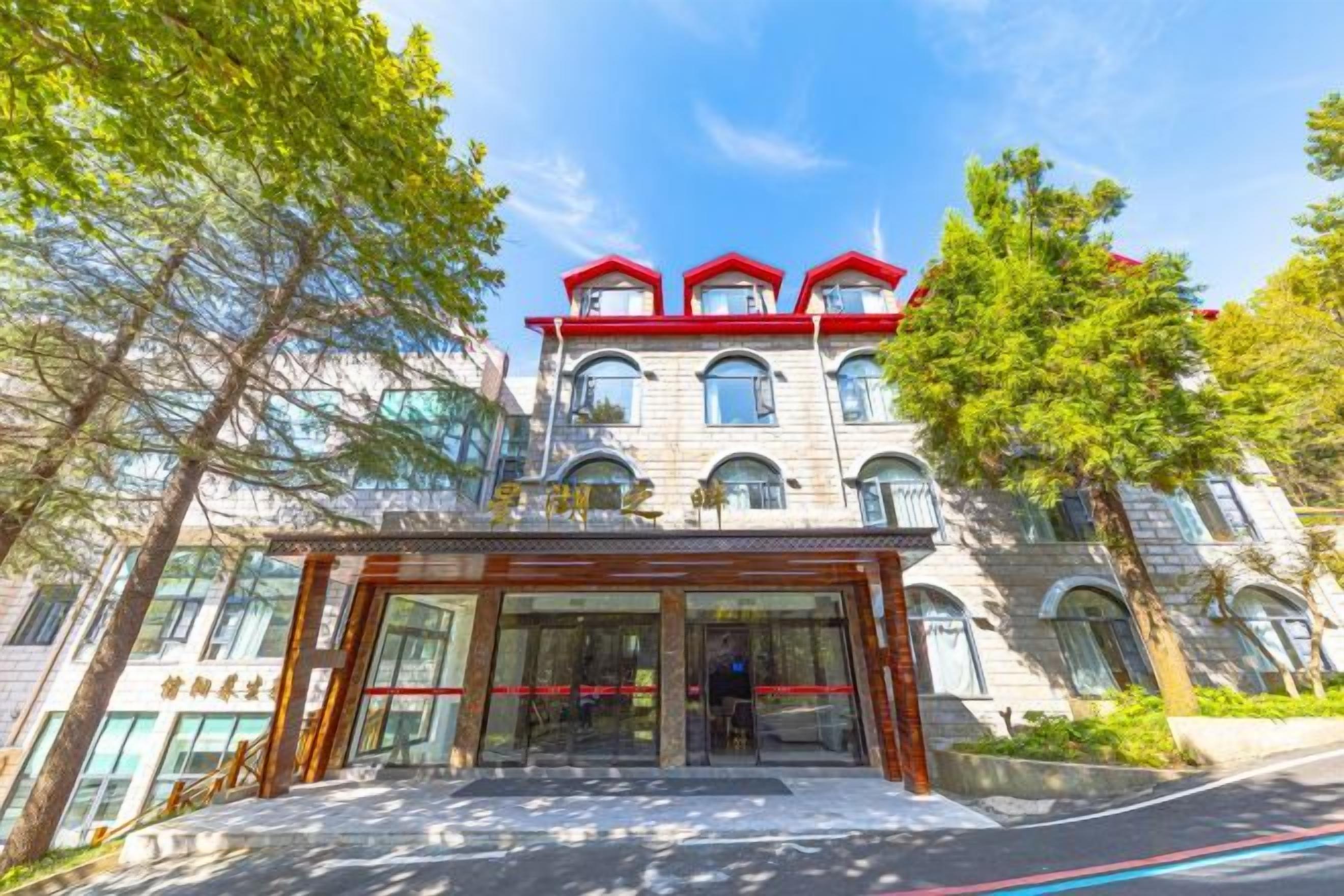 A multi-story hotel with a prominent entrance, large windows, and a red roof.