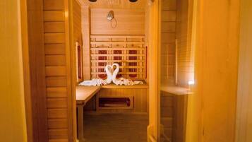 Un cuarto de sauna con paredes y bancos de madera, un perchero y un banco con una toalla.