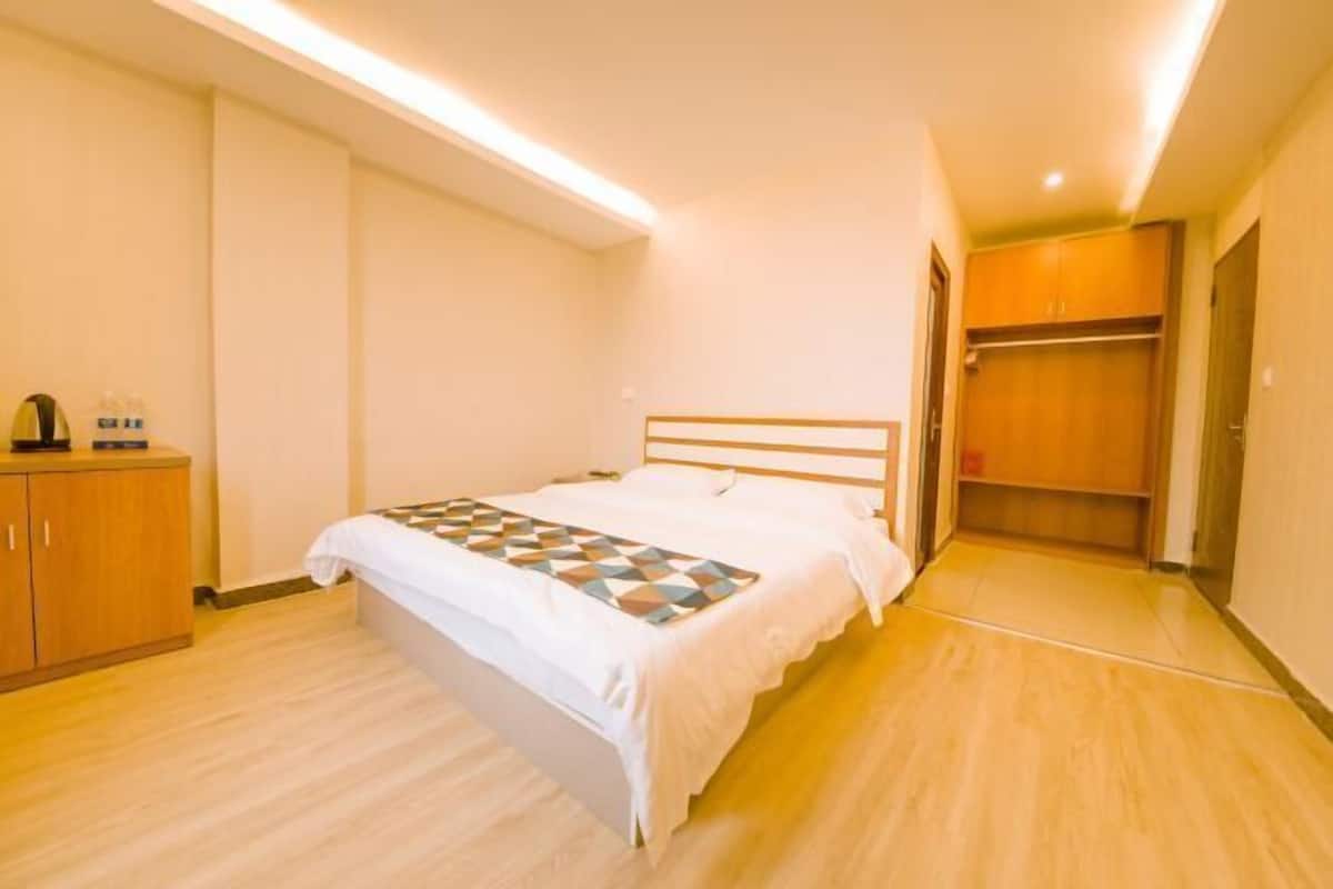 Ein Hotelzimmer mit einem Bett, einem Kleiderschrank und einem Nachttisch.