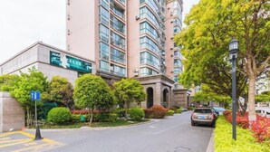 Un immeuble résidentiel à plusieurs étages, doté d’une architecture moderne, de balcons et de grandes fenêtres.