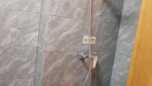Ein Duschbereich mit Handbrause und fest installierter Bedienkonsole.