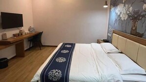 A hotel room with a bed, a desk, a television, and a mural on the wall. - Naiman Banner Water Yun Tiancheng Hotel (Naiman Banner)