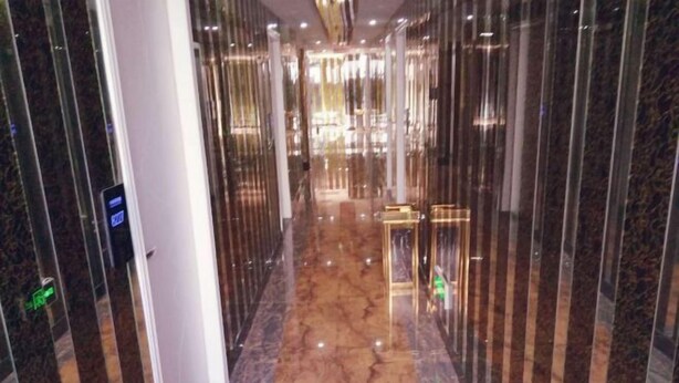 A corridor with reflective glass panels and a polished marble floor. - Blue Wave 128 Pulai Hotel (Shanghai)