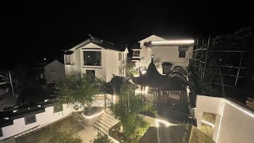 Un quartier résidentiel de nuit, avec des allées éclairées et une construction de style traditionnel.