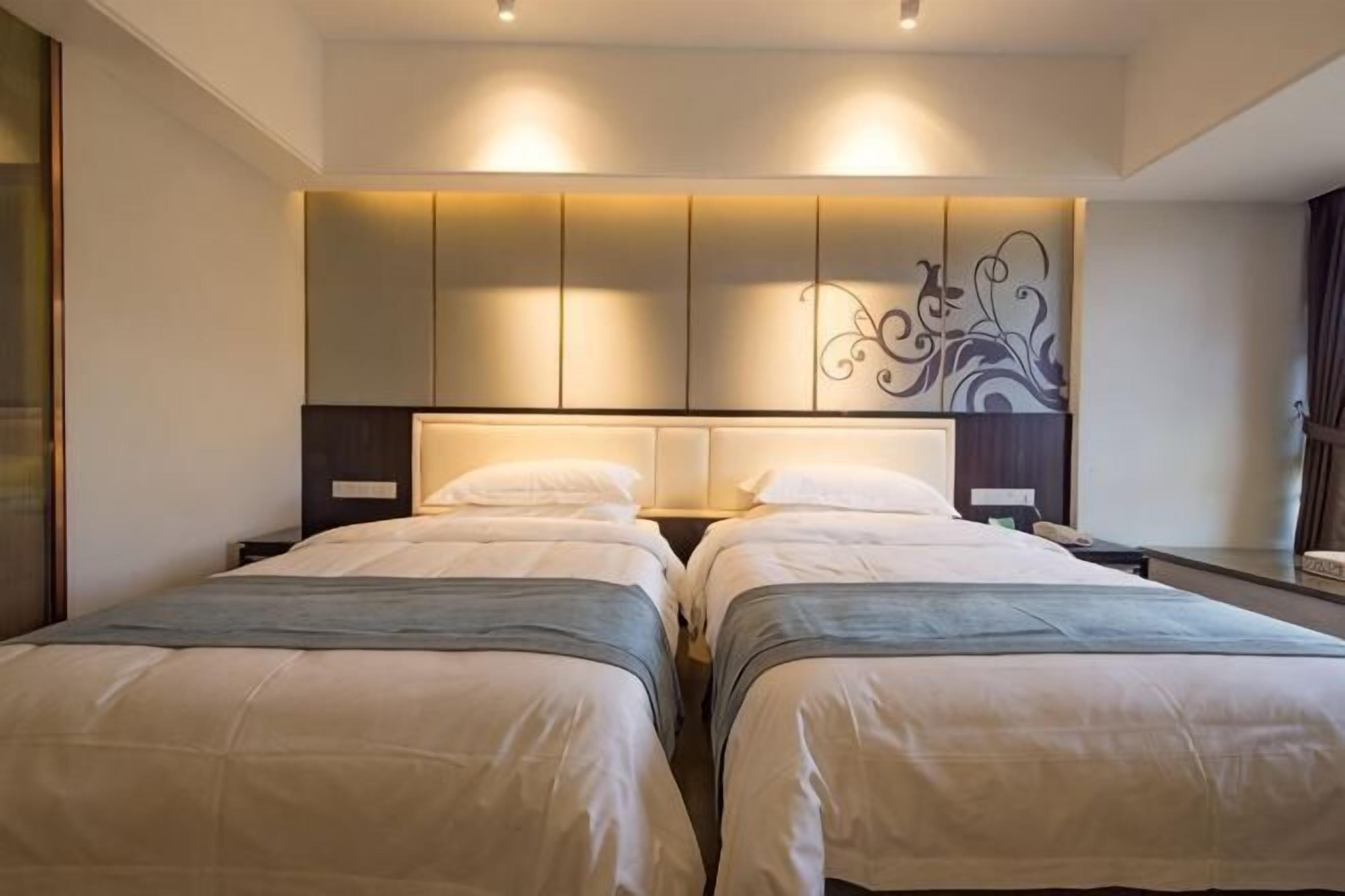 Habitación doble con cama, mesitas de noche y un adorno en la pared.