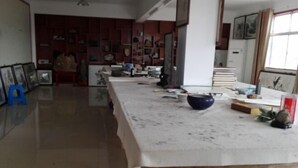 A spacious room with a long table, various artworks, and a bookshelf filled with books and decorative items. - Jing County Zhenshan Mountain Villa (Jing County)