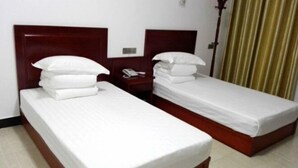 Two single beds with wooden headboards and white bedding in a hotel room. - Jing County Zhenshan Mountain Villa (Jing County)