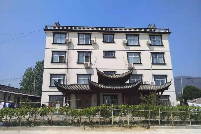 A multi-story building with a traditional architectural style, featuring a central entrance with a curved roof.