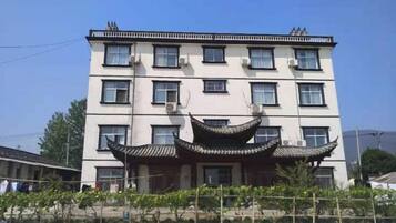 A multi-story building with a traditional architectural style, featuring a central entrance with a curved roof.