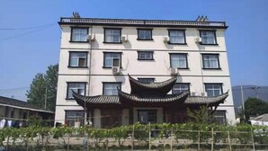 A multi-story building with a traditional architectural style, featuring a prominent curved roof structure. - Jing County Zhenshan Mountain Villa (Jing County)