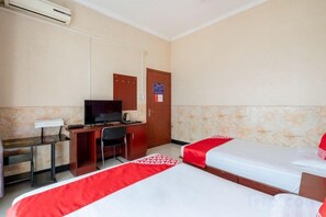 A hotel room with two beds, a desk with a chair, a television, and an air conditioning unit. - Feiyu Hostel (Shanghai)