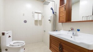 A bathroom with a toilet, sink, mirror, and shower. - Feiyu Hostel (Shanghai)