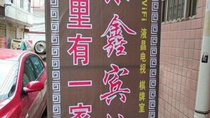 Un letrero con caracteres chinos que indica un hotel con servicio de WiFi y telefónico.