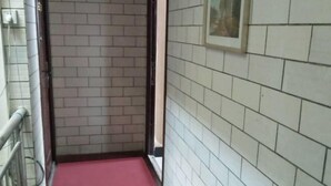 A narrow hallway with a red carpet, white tiled walls, and a metal railing on one side. - xiandongxinbinguan (Xi'an)