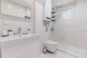 Bathroom features a large bathtub, separate toilet, and shower area.