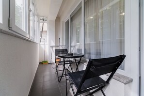 Enjoy dining or relaxing in this stylish balcony with a round table and two chairs.