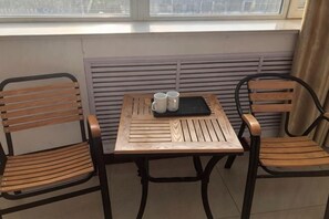 A small table with two chairs, a window, and a radiator. - Minnan Lingang Mingdu Hotel (Junan County)