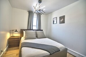 Un dormitorio moderno con cama, lámpara de noche y una lámpara de techo original.