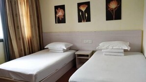 A hotel room with two single beds, a nightstand, and three wall-mounted flower paintings. - Jinju Hostel (Shanghai)