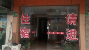 A hotel entrance with a glass door and red signage. - Jinju Hostel (Shanghai)