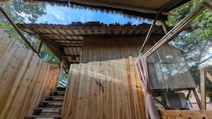 A wooden staircase leading to a covered area with a thatched roof. - Jiayiyuan Farm (Kaiping)