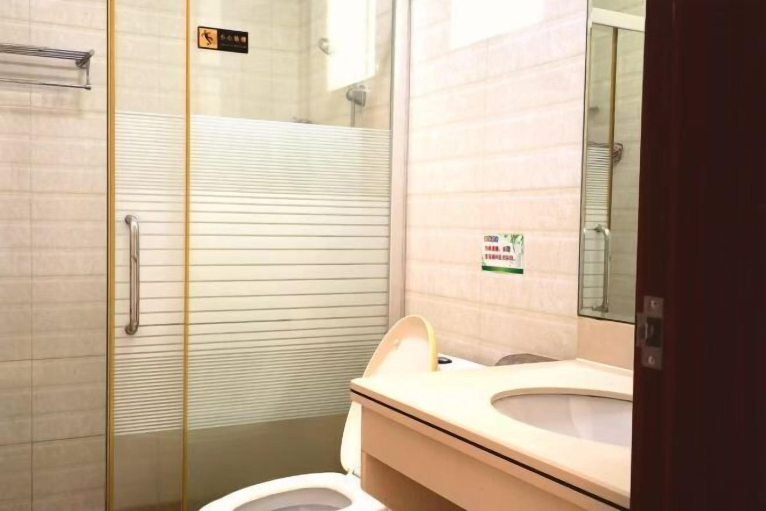 A modern bathroom with a glass shower enclosure, a white toilet, and a sink with a mirror.