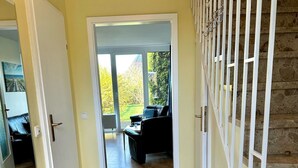 A hallway with a wooden bench, a radiator, and a staircase with white railings.