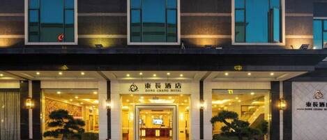 The exterior of Dong Chang Hotel with a modern facade, large windows, and a welcoming entrance.