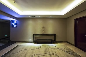 A hotel lobby with a reception desk, a digital clock displaying the time, and a patterned carpet. - Dong Chang Hotel (Dongguan Hengli China Resources Shopping Plaza) (Dongguan)