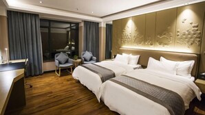 Une chambre d’hôtel avec deux lits, un bureau et une chaise.
