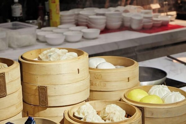 Bamboo steamers with dumplings and a variety of bowls and plates.