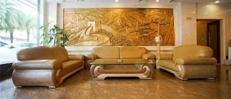 Un vestíbulo con un gran mural en la pared, sofás de cuero y una mesa de centro.