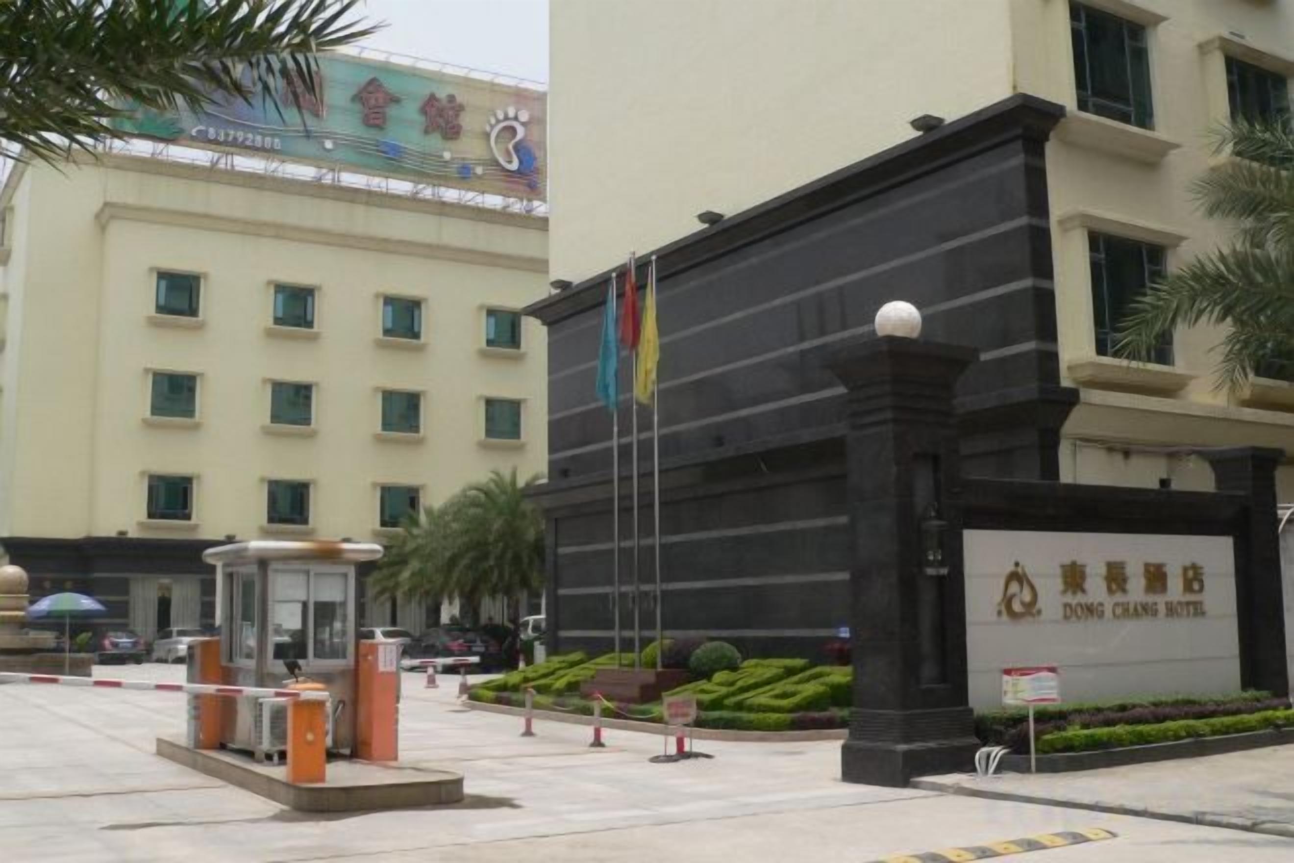 A hotel entrance with a black facade, a traditional Chinese architectural style, and a sign indicating the name 'Dong Chong Hotel'.